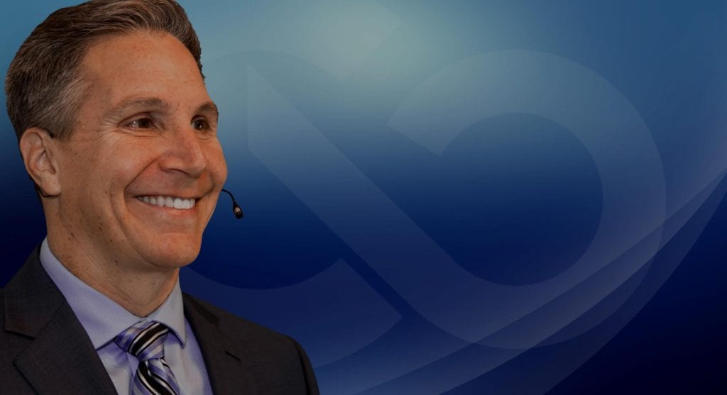 A man with a headset on smiling for the camera.